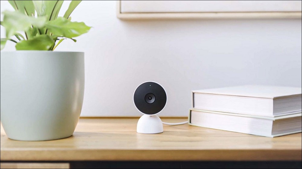 A Google Nest wired security camera sitting on a table in a home.