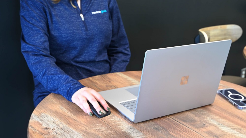 A person at a cafe using the Dell Portable Ms700 Mouse