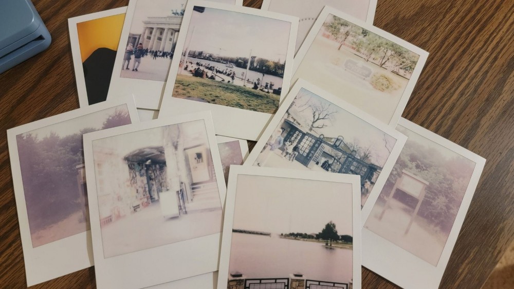 close up of some instant photos on a wooden desk